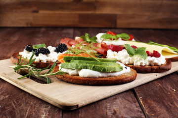 Bread Brushetta or authentic traditional spanish tapas set for lunch table. Sharing antipasti on party or summer picnic time over wooden rustic background.