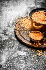Seeds of lentils in a bowl . On rustic background.