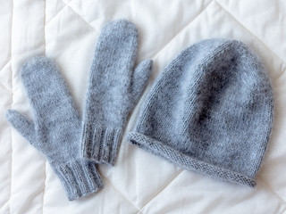 Hat and mittens connected by hand from wool
