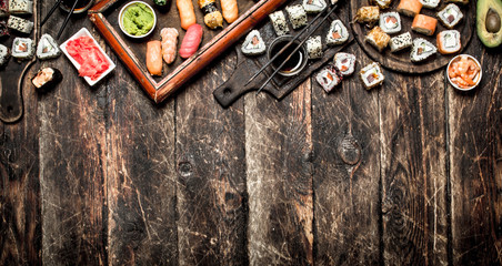 Japanese food. Fresh sushi and rolls with soy sauce. On the old wooden background.
