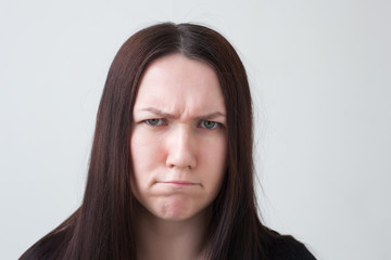 Girl frowns and looks forward with displeasure. She was disappointed and angry