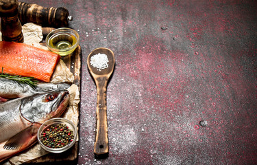 Fresh fish with a piece of fillet and spices. On rustic background.