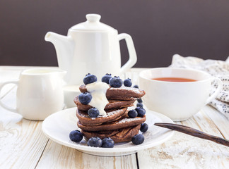 Hot tea and buckwheat chocolate pancakes with blueberries