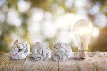 Idea with a crumpled office paper and light bulb .