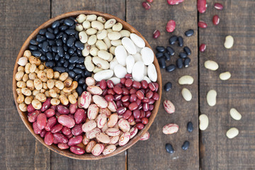 Assortment of different types of beans - red beans, chickpeas, peas in wooden bowl. top view.