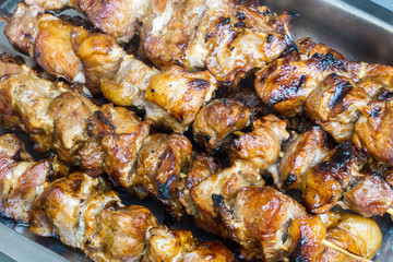 A pork skewer stick on the grill