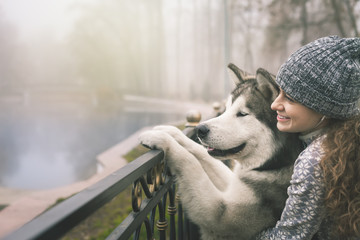 Image of young girl with her dog, alaskan malamute, outdoor