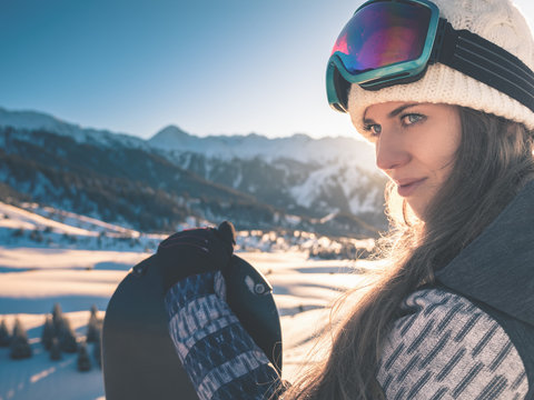 Portrait of snowboarder girl on the background of high mountain