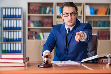 Handsome judge with gavel sitting in courtroom