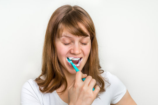 Woman brushing her teeth with toothbrush in the morning