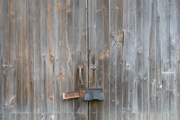 Barn door with rust. Unfiltered doors, with natural lighting. An old gray rustic barn surface.