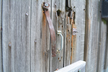 Barn door with rust. Unfiltered doors, with natural lighting. An old gray rustic barn surface.