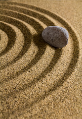 Grey stone on brown sand.