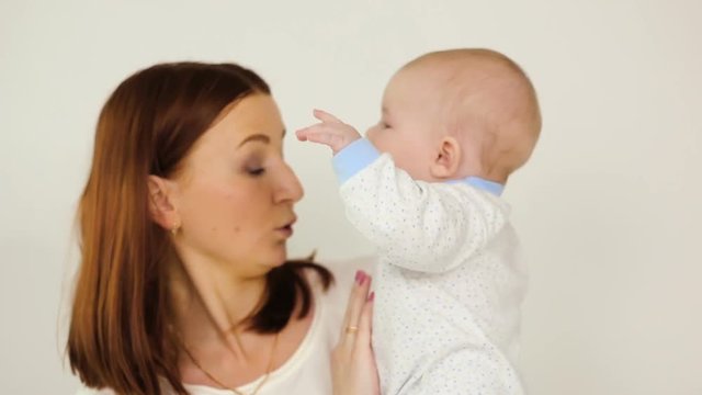 mother holding son with a pacifier on a white background