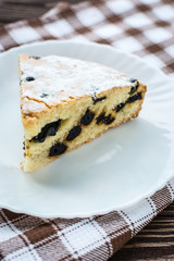 Сherry pie sprinkled powdered sugar on wooden background