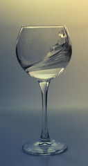 Splash water in a glass on a gray background