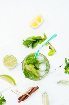 Mojito cocktail with lime and mint in highball glass on a wood white background