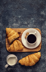 Croissants and coffee on a dark background