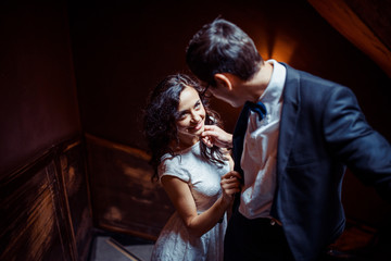 Fashionable young couple standing on stairs and hugging each other