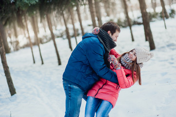 Fototapeta na wymiar Happy Young Couple in Winter Park having fun.Family Outdoors