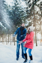 woman and man having fun in winter forest