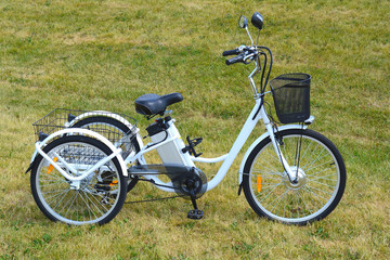 Electric trike or bicycle in the park in sunny summer day. Shot from the side. Unfiltered, with...