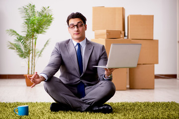 Businessman meditating on the office floor