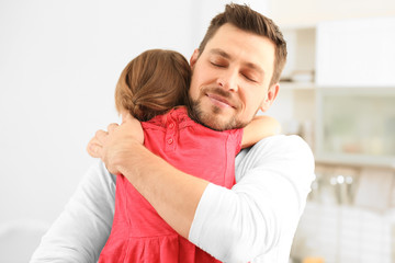 Girl embracing father at home