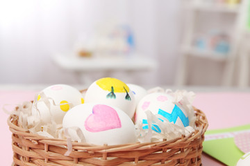 Obraz na płótnie Canvas Wicker basket with Easter eggs on blurred background, closeup