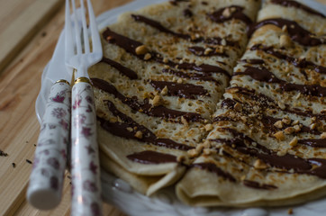 Pancakes with chocolate sauce and nuts for breakfast
