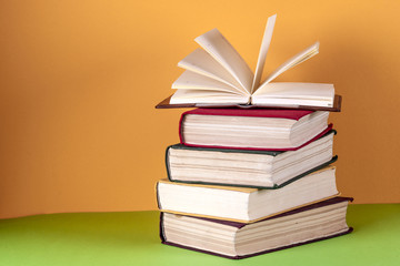 Open book, hardback bookson bright colorful background.