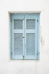 stare jasnoniebieskie okiennice na bielonym budynku, Mykonos, Grecja - 138607468