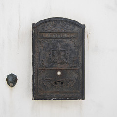 zardzewiała stara skrzynka pocztowa i dzwonek do drzwi na białej ścianie - 138608234