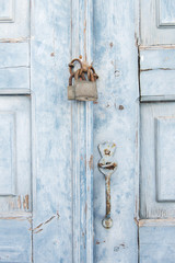 stare jasnoniebieskie drzwi z rdzawym zamkiem i klamką w Mykonos w Grecji - 138608697