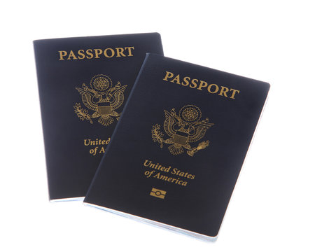 Two United States of America passports isolated on a white background. A passport is necessary for travel outside of the country, including via cruise ships.