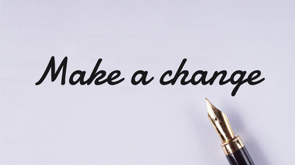 "Make a change" words written on white paper using fountain pen - business and finance concept