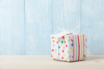 Polka dot gift box on wooden table - 138610625