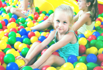 portrait of  girl playing in pool with plastic multicolored ball