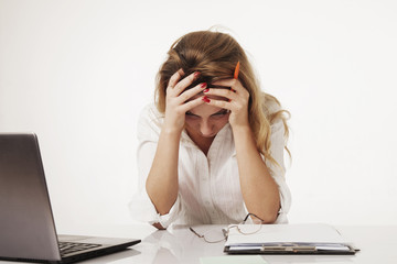 Young tired, stressed and frustrated business woman desperate working at office with laptop