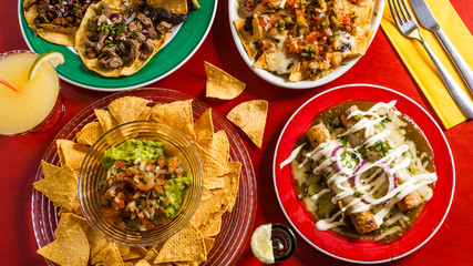 Mixed mexican food: Guacamole, nachos, fajita, meat tacos. Top view. Tex-mex cuisine. Assorted...