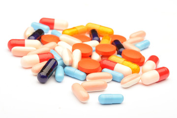 Colored pills, tablets and capsules on a white background