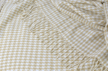 Soft woolen blanket with beige and white hounds-tooth pattern and with heather