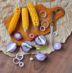 Corn and onion on cutting board.