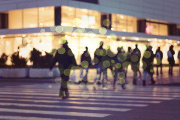 picture with motion blur of a crowd of people crossing a city street at the pedestrian crossing