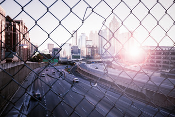 Morning city skyline through the wire mesh fence