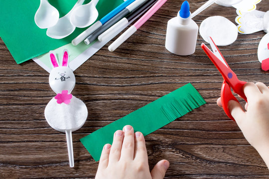 The child sticks gift items. Children's Easter gift toy Rooster and the Easter Bunny. Made by hand. Children's Art Project, needlework, crafts for children.