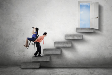 Businessman carrying his partner on stairs