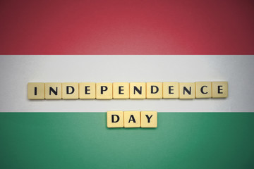 Naklejka premium letters with text independence day on the national flag of hungary.