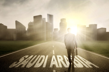 Fototapeta premium Businessman with suitcase and Saudi Arabia word