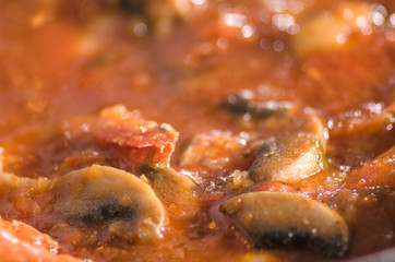 Sauce with tomatoes and shrimps in a pan during cooking.